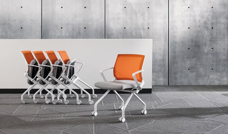 Orange nesting chair showcased in both closed-flipped and open positions to illustrate its versatile design.