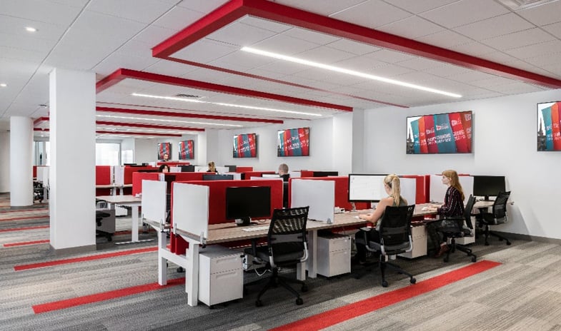 A corporate office with cubicles in brand-red, reflecting the company's signature color scheme.