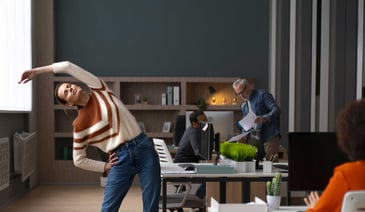 A woman stretching during a workday in the office.