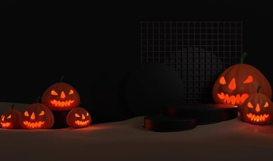 Jack-o'-lanterns with carved faces glowing orange against a dark background.