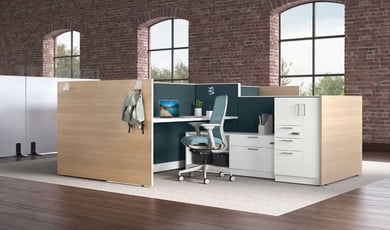 A modern office cubicle setup with wooden panels, teal accents, and exposed brick walls.