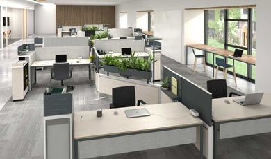 A modern open office space with light-colored desks, black chairs, and indoor plants scattered throughout.