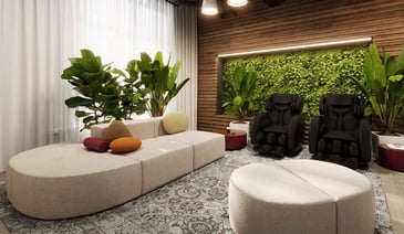 Modern relaxation room with cream seating, massage chairs, and living green wall.