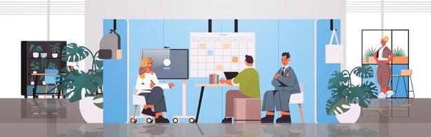 Team meeting in a collaborative space with whiteboard, moveable TV, surrounded by office plants and decor.