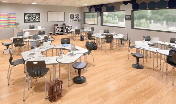 Flexible classroom layout with desks, stackable chairs, and educational posters on the wall.