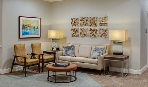 Kwalu Volterra Lounge and sofa in a warm neutral living room setting with decorative wall art and table lamps.