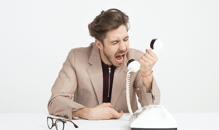 An employee conveying urgent information over the telephone, expressing strong emotions.