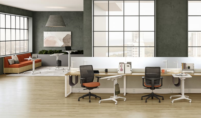 A spacious open office layout with three workstations and a welcoming lounge area adjacent, providing a versatile and collaborative workspace environment.