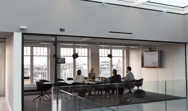 Employees gathered inside a conference room, engaged in a productive meeting.