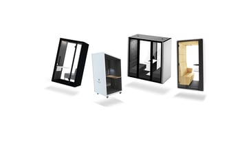 Four contemporary office phone booths featuring comfortable seating and tables inside. These booths are specifically designed to offer privacy and enhance productivity within the dynamic setting of an open office environment.