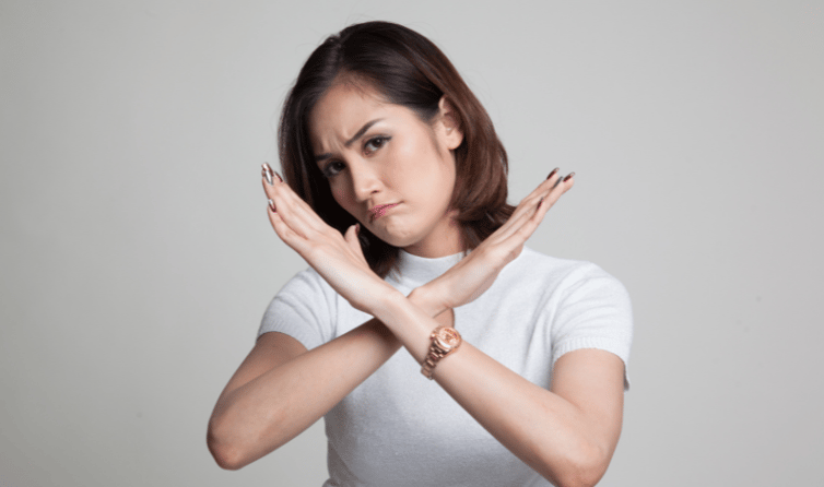 A woman with crossed arms wearing a sad expression.