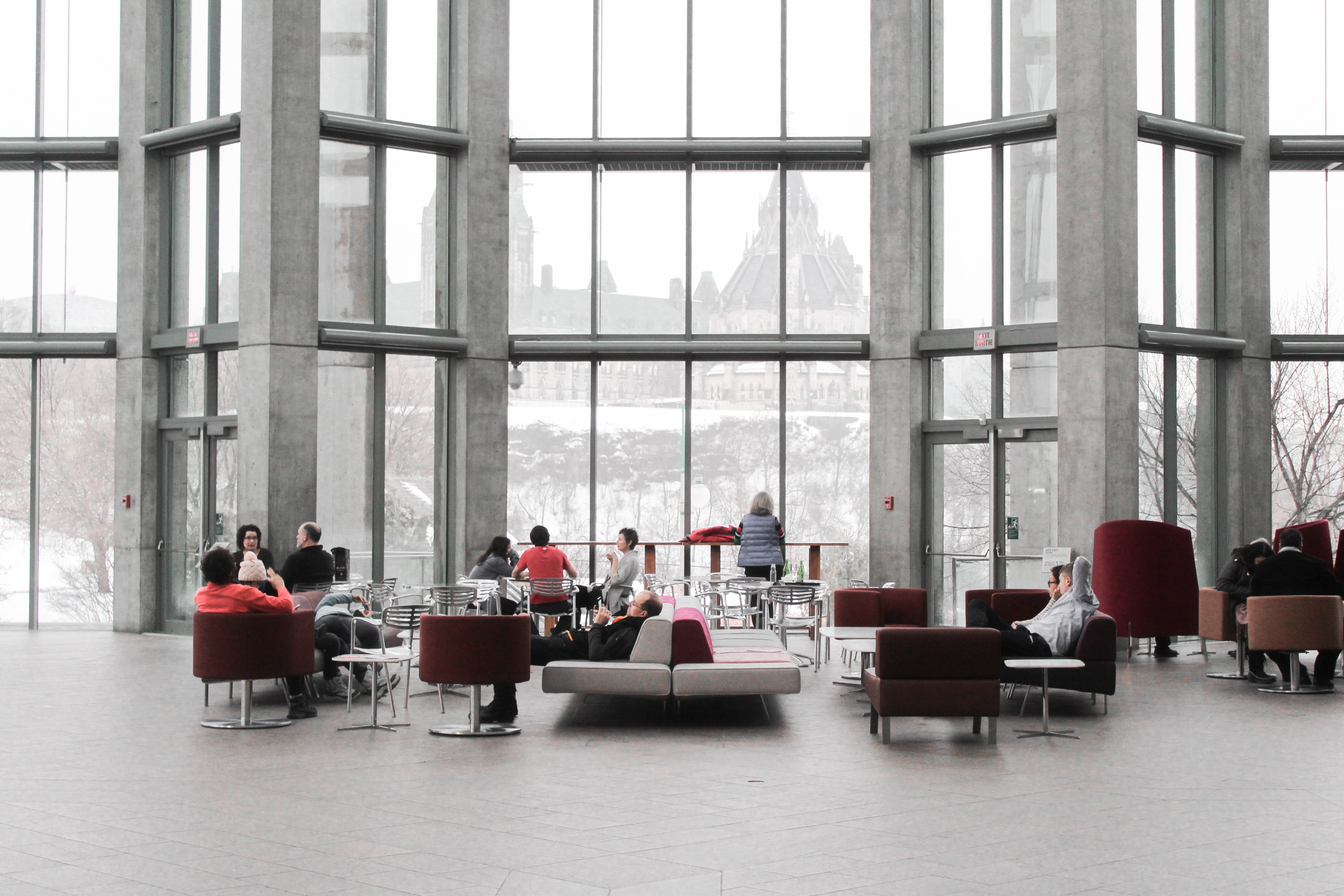 A spacious office lounge with people seated and engaged in conversation.