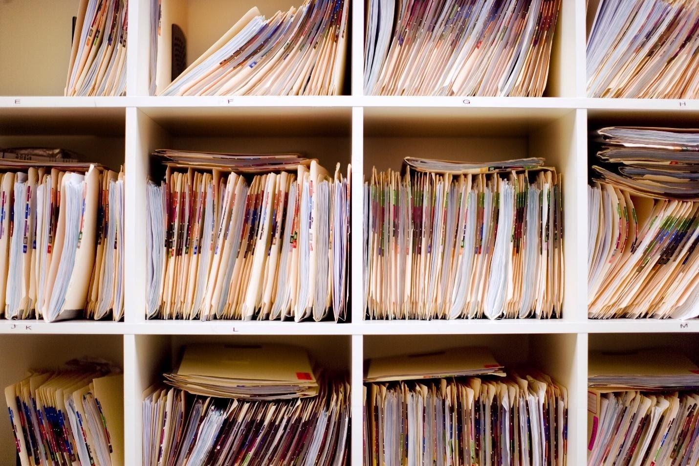 A well-organized bookshelf displaying arranged folders and assorted documents.