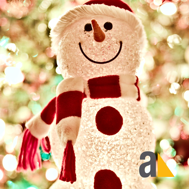 A cheerful snowman adorned with colorful Christmas lights against a festive backdrop.